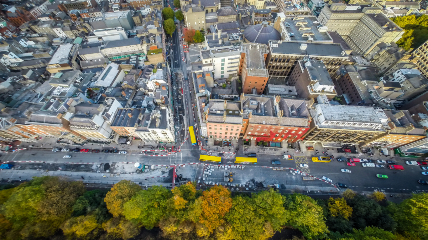 Aerial view of vibrant cityscape, lush park, historic architecture, bustling streets; perfect for exploring urban attractions.
