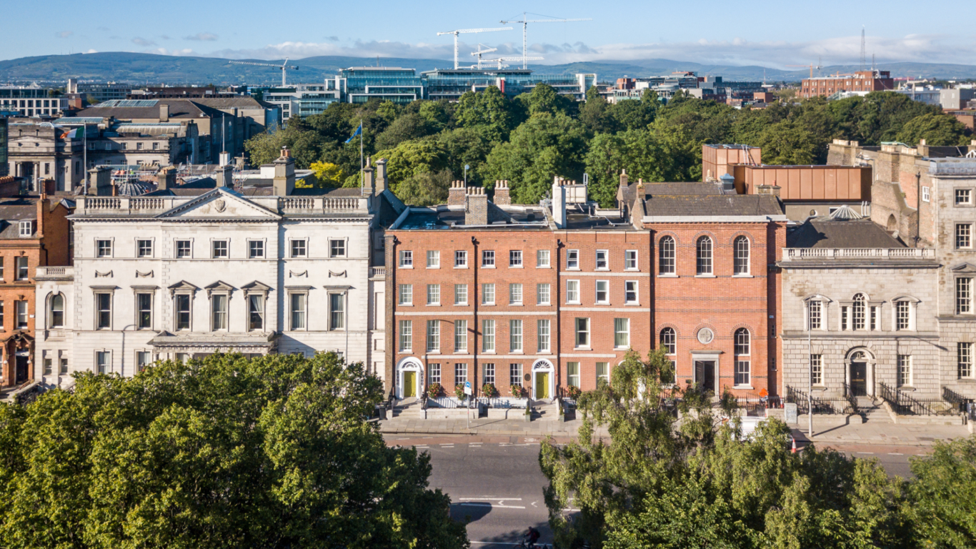 Elegant Georgian hotel facade with city views, lush greenery, and inviting atmosphere near Dublin's vibrant centre.